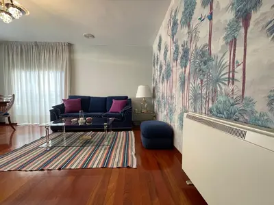 a living room with a blue couch and a table at Oktheway Rua Nova 3D in Sarria