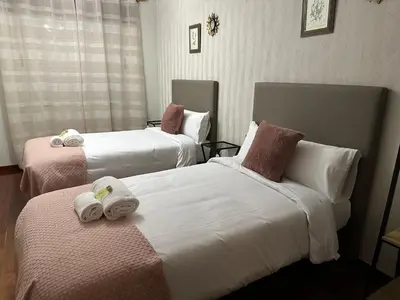 a hotel room with two beds with towels on them at Oktheway Rua Nova 3D in Sarria