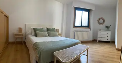 a bedroom with a large bed and a window at O Pequeno Rincón in Allariz