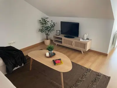 a living room with a tv and a coffee table at O Pequeno Rincón in Allariz