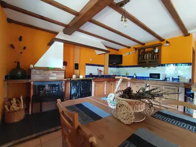 a kitchen with a wooden table and yellow walls at A Porteliña Casa Rural, entre viñedos y castaños in Ambas Aguas