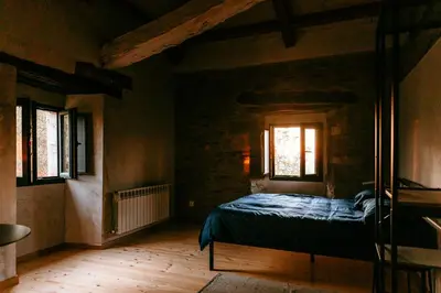 a bedroom with a bed and two windows at Apartamento turístico rural Casa Chaín in Lugo