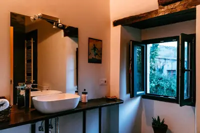 a bathroom with a white sink and a window at Apartamento turístico rural Casa Chaín in Lugo