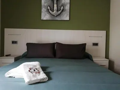 a bedroom with a bed with a towel on it at PENSION PORTA SANTA in Baleira