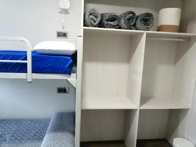 a small room with white shelves and a bed at PENSION PORTA SANTA in Baleira