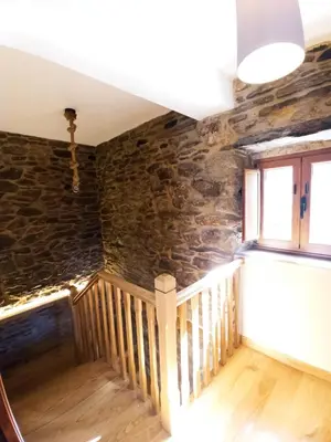a staircase in a room with a stone wall at Casa Carmelo in Viveiro