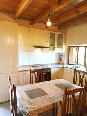 a kitchen with a table and a table and chairs at Casa Carmelo in Viveiro