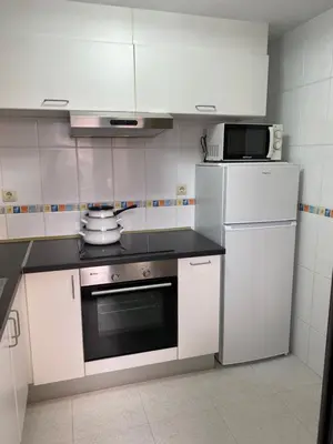 a kitchen with a stove and a microwave and a refrigerator at O SECRETO in Padrón