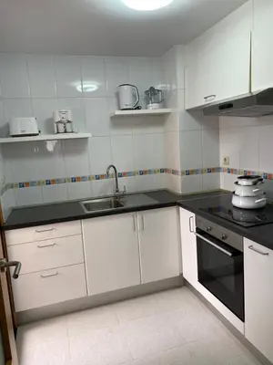 a kitchen with white cabinets and black counter tops at O SECRETO in Padrón