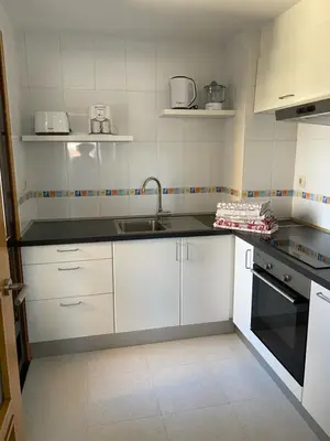 a kitchen with white cabinets and a sink at O SECRETO in Padrón