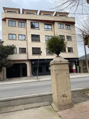 a building on the side of a street with a plant at O SECRETO in Padrón