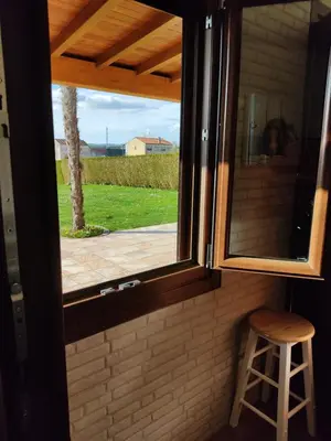 a window in a room with a stool next to it at A Chamiseiriña in Padrón