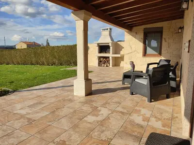an outdoor patio with chairs and a fireplace at A Chamiseiriña in Padrón