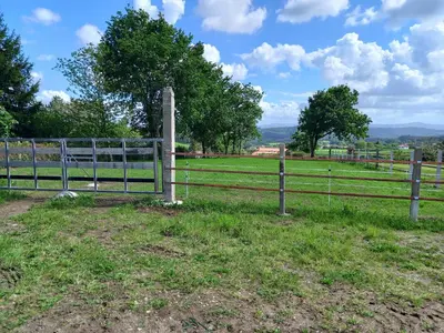 a fence in a field with trees in the background at Hotel La Puerta de Arzúa in Arzúa