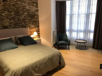 a bedroom with a bed and a brick wall at APARTAMENTOS ARMANYA 3 in Lugo