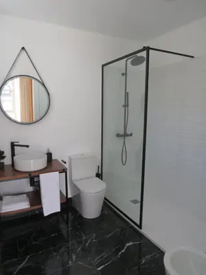a bathroom with a shower and a toilet and a mirror at APARTAMENTOS ARMANYA 3 in Lugo