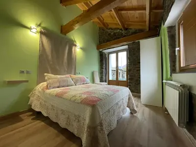 a bedroom with a bed in a room with green walls at Casa Osu Pardo VuT in Caboalles de Abajo