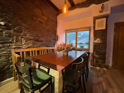 a dining room with a wooden table and chairs at Casa Osu Pardo VuT in Caboalles de Abajo