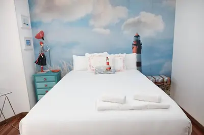 a bedroom with a white bed with a lighthouse on the wall at Lujoso y amplio piso con 5 habitaciones in Santiago de Compostela