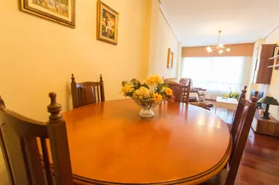 a dining room table with a vase of flowers on it at Casa Goros I in Melide