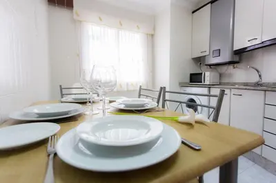 a dining room table with white plates and wine glasses at Casa Goros I in Melide