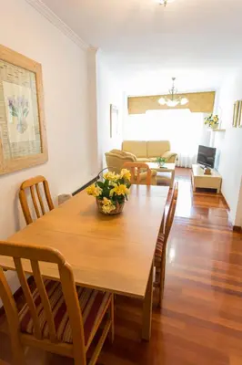 a dining room and living room with a table and chairs at Casa Goros II in Melide
