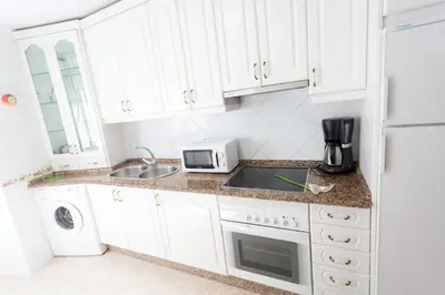a white kitchen with a sink and a microwave at Casa Goros II in Melide