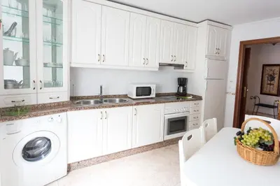 a kitchen with white cabinets and a sink and a microwave at Casa Goros II in Melide