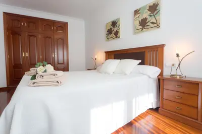 a bedroom with a large white bed with white sheets at Casa Goros II in Melide