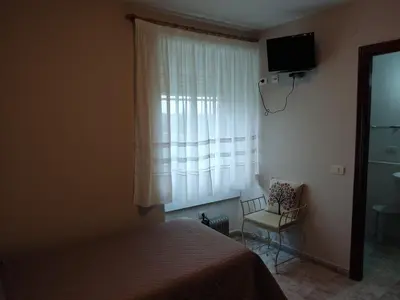 a room with two beds and a table with a lamp at OS MUIÑOS in Ribadeo