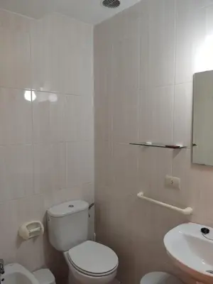 a white bathroom with a toilet and a sink at OS MUIÑOS in Ribadeo