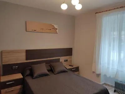 a bedroom with two beds and a table with a lamp at OS MUIÑOS in Ribadeo