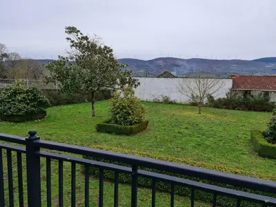 a black fence in a yard with a tree at Chalet do Médico in Rodeiro