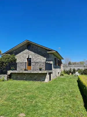 an old stone house with a porch and a yard at Chalet do Médico in Rodeiro
