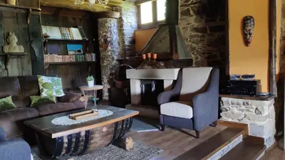 a living room with a couch and a fireplace at Casas Eladio-Doncos in Torés