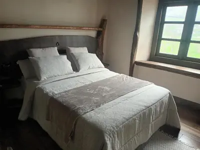 a bedroom with a large bed with white sheets and pillows at Casas Eladio-Doncos in Torés