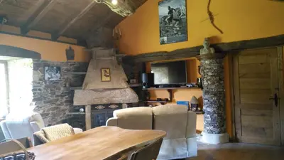 a kitchen with a wooden table and a stone stove at Casas Eladio-Doncos in Torés
