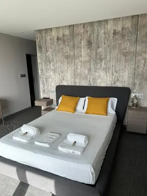 a large bed with yellow pillows and towels on it at Tres Prismas Exclusive in Sarria