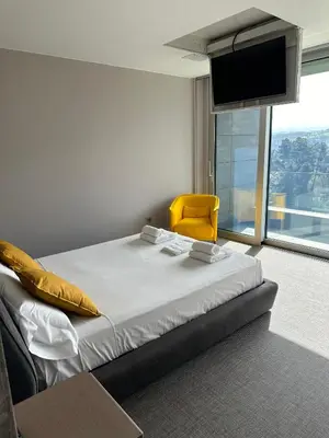 a hotel room with a bed and a yellow chair at Tres Prismas Exclusive in Sarria