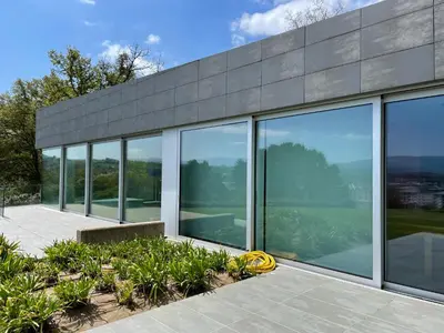 a building with large glass windows and plants at Tres Prismas Exclusive in Sarria