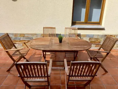 a wooden table and chairs with a potted plant on it at Tapia in Tapia de Casariego