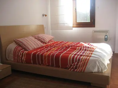 a bed with a red and white blanket and a window at Tapia in Tapia de Casariego