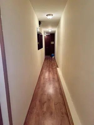 a hallway with white walls and a wooden floor at Pensión Carballeira in Arzúa