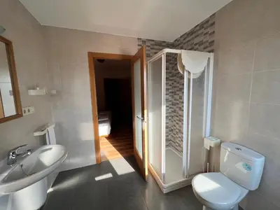 a bathroom with a toilet and a sink at Pensión Carballeira in Arzúa