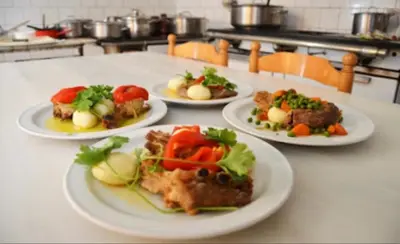 four plates of food on a table in a kitchen at Pensión Carballeira in Arzúa
