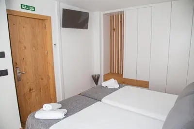 a bedroom with a bed with towels on it at Pensión Praza das Coles in Melide