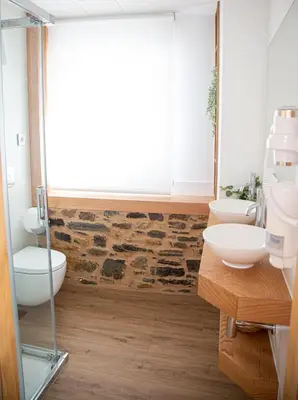 a bathroom with two sinks and two toilets at Pensión Praza das Coles in Melide