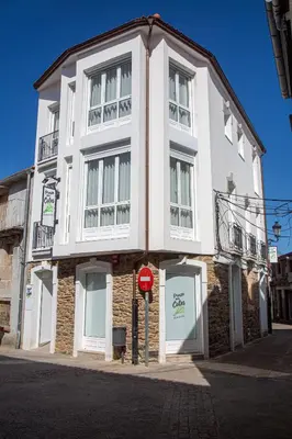 a white building with a stop sign in front of it at Pensión Praza das Coles in Melide