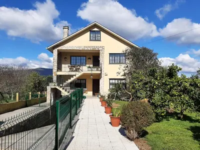 a house with a fence in front of it at Apartamento AS CARBALLAS in Caldas de Reis