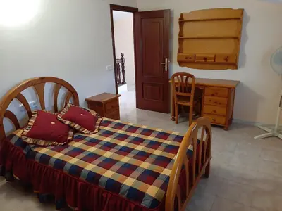 a bedroom with a bed and a dresser and a desk at Apartamento AS CARBALLAS in Caldas de Reis